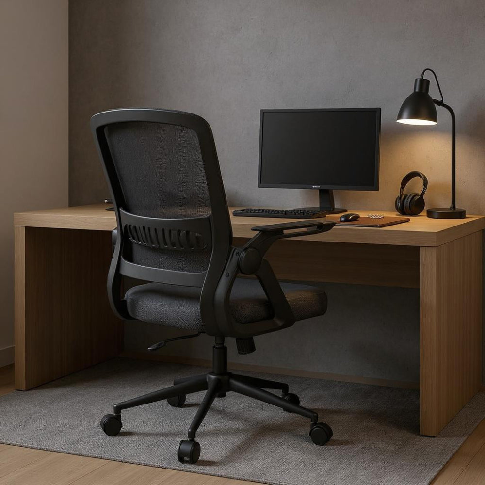 Chaise ergonomique noire avec dossier en maille dans un bureau sombre