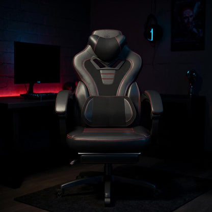 Chaise gaming noire avec coussin massant et repose-pieds dans un setup rouge